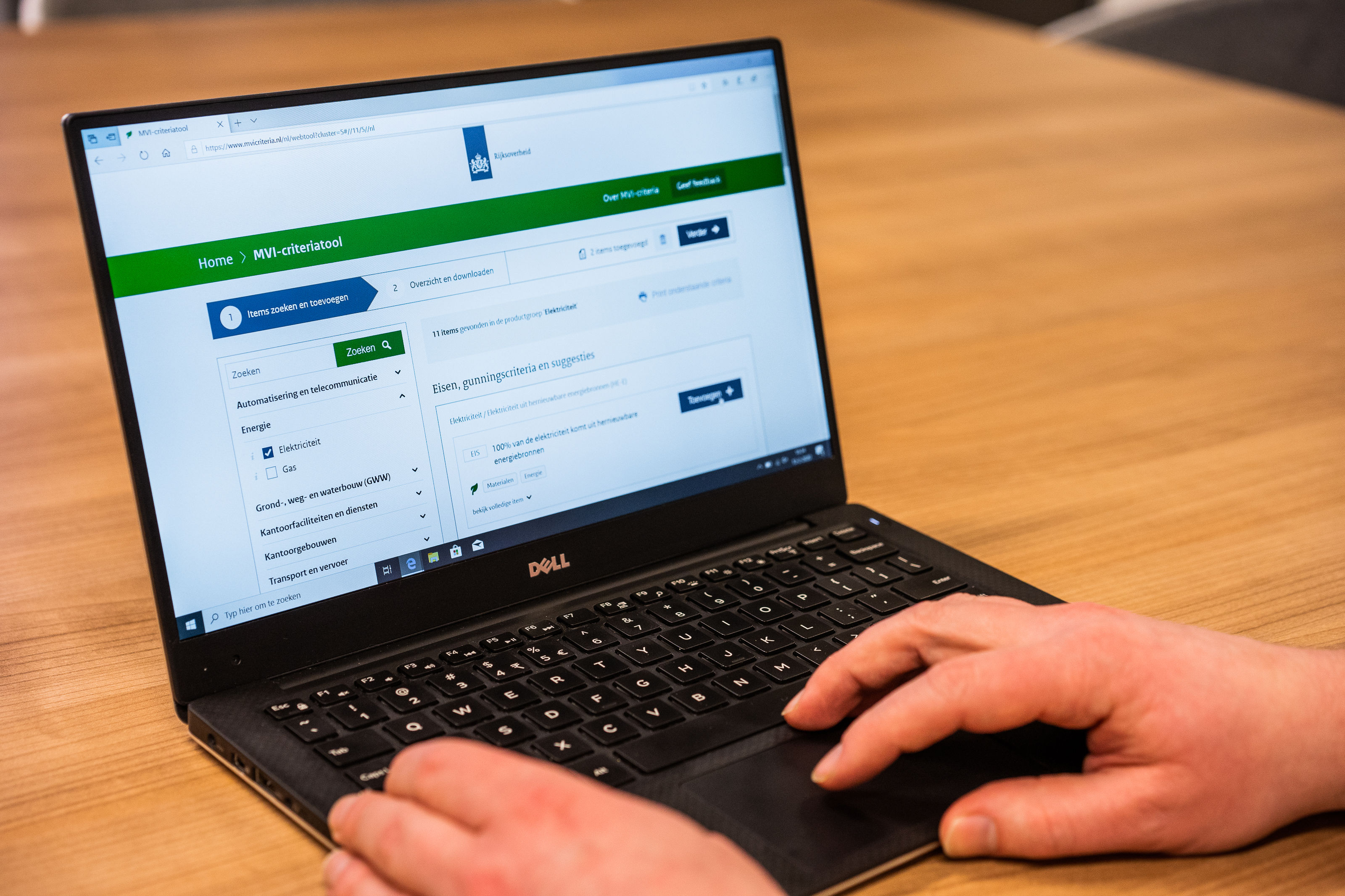 Een foto van iemand achter een laptop die de website MVI criteriatool gebruikt