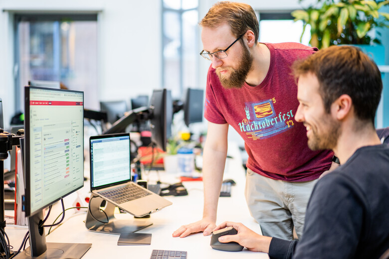 Scrum Master Rien en Product Owner Thomas bekijken een backlog